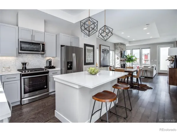 a kitchen with stainless steel appliances a table chairs and a refrigerator