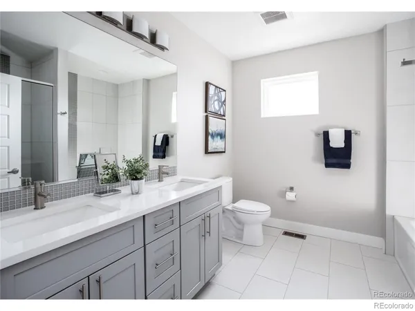 a bathroom with a granite countertop toilet a sink and a mirror