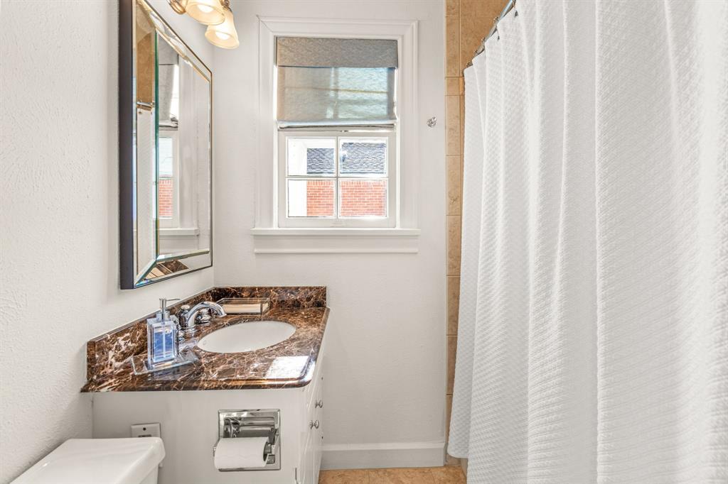 3628 Potomac Avenue Fort Worth, TX 76107 - Photo 28 of 32 a bathroom with a granite countertop sink and a mirror