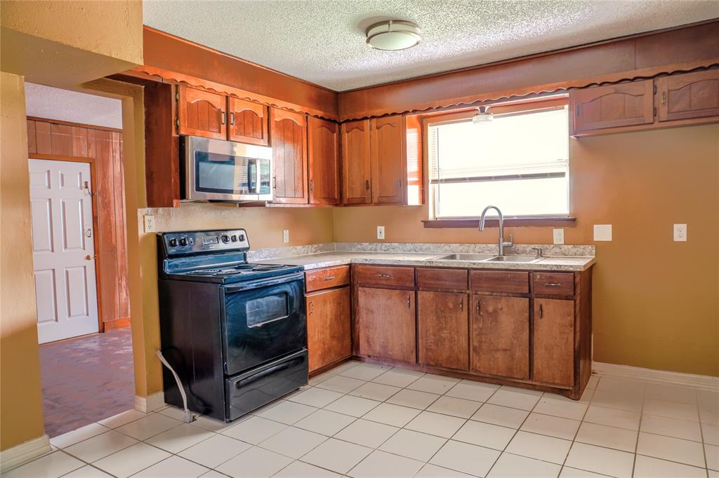 300 Coury Road Everman, TX 76140 - Photo 7 of 29 a kitchen with stainless steel appliances granite countertop a sink and a stove