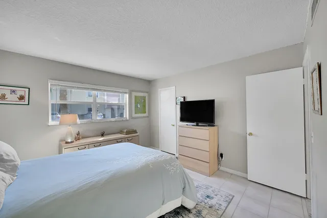 a bedroom with a bed and a flat screen tv