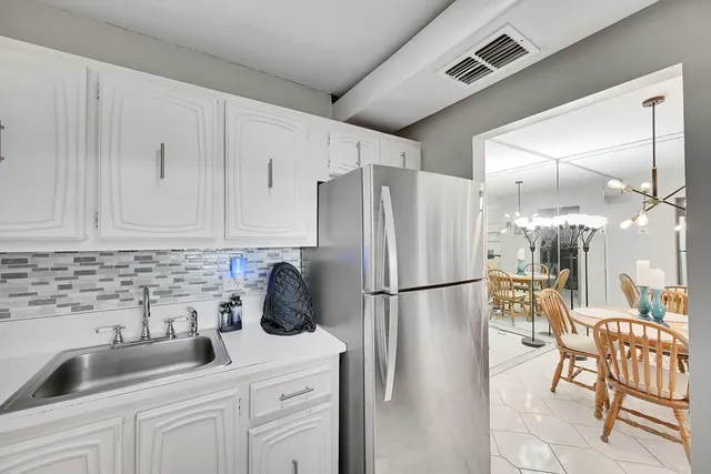 a kitchen with white cabinets stainless steel appliances and sink