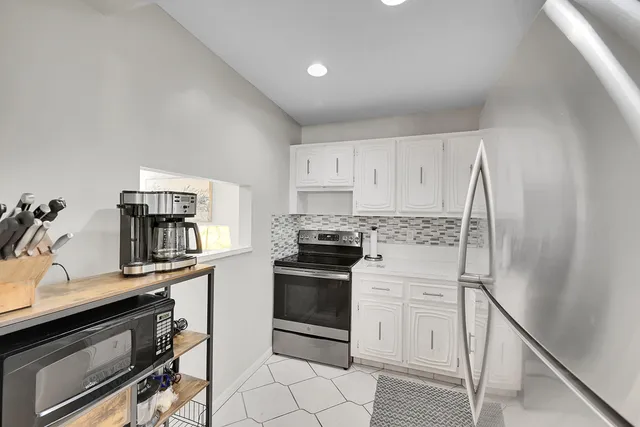 a kitchen with a sink a refrigerator and cabinets