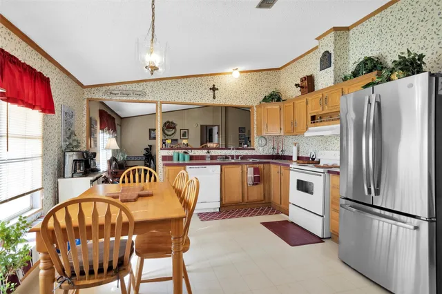 a kitchen with stainless steel appliances granite countertop a refrigerator a stove a sink and a microwave