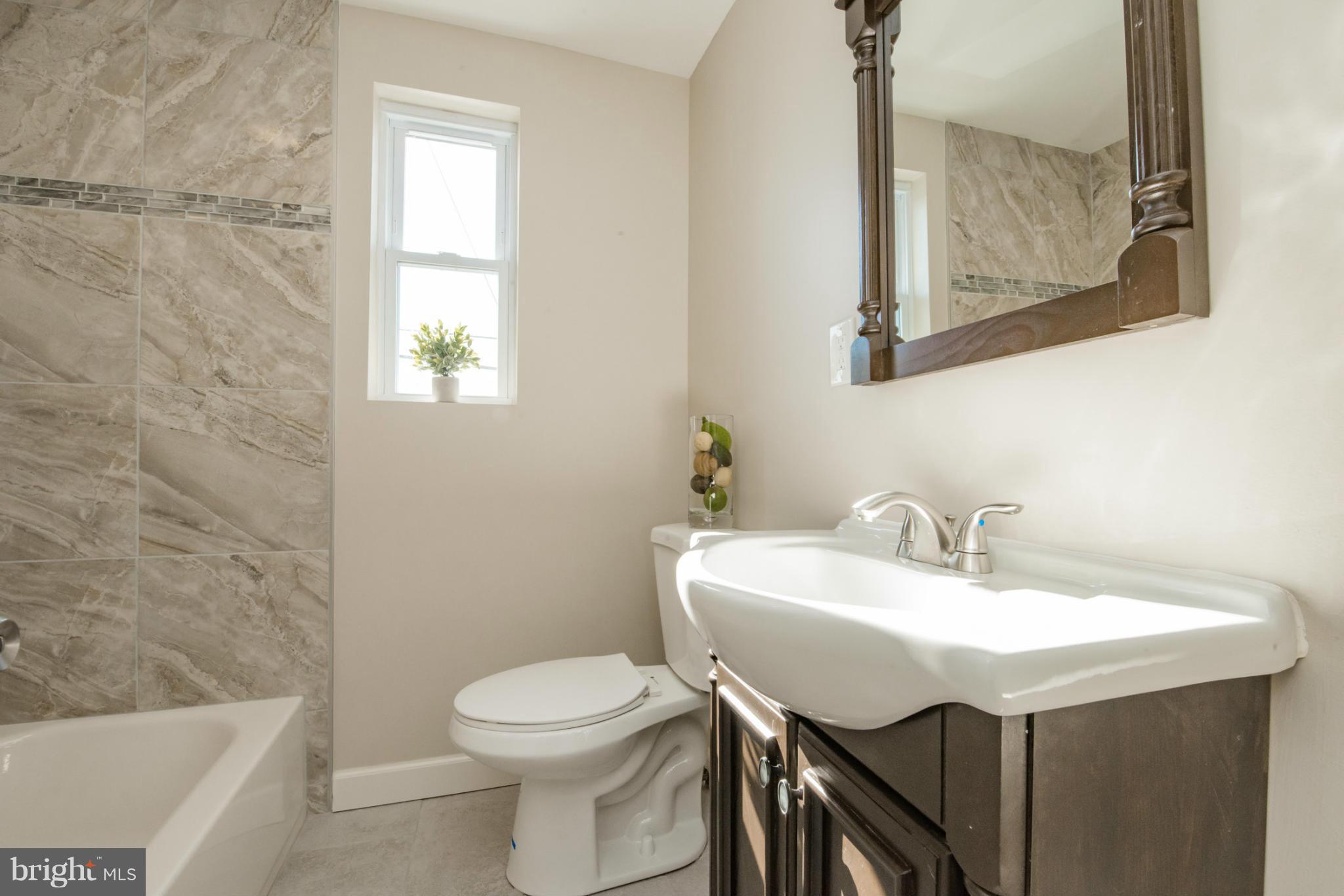 6922 Reisterstown Road Baltimore, MD 21215 - Photo 16 of 30 a bathroom with a sink and a toilet