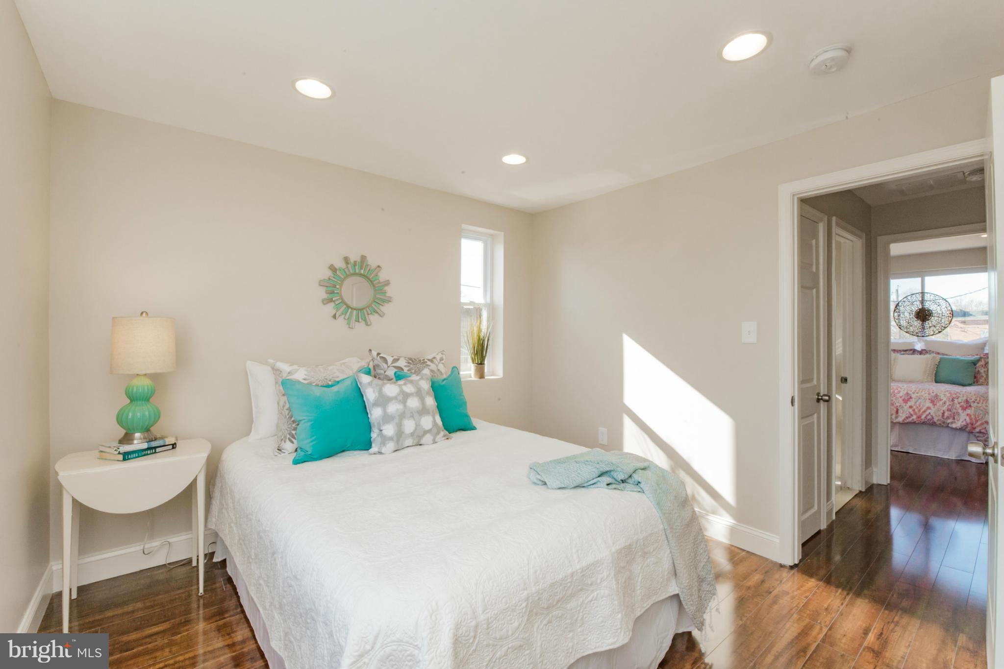 6922 Reisterstown Road Baltimore, MD 21215 - Photo 19 of 30 a bedroom with a bed and wooden floor
