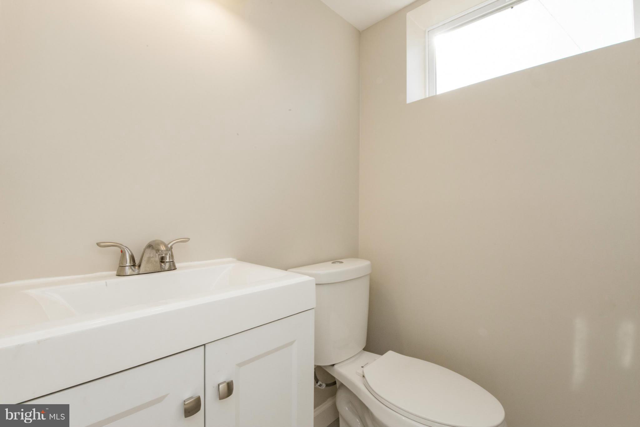 6922 Reisterstown Road Baltimore, MD 21215 - Photo 25 of 30 a bathroom with a sink a toilet and a mirror