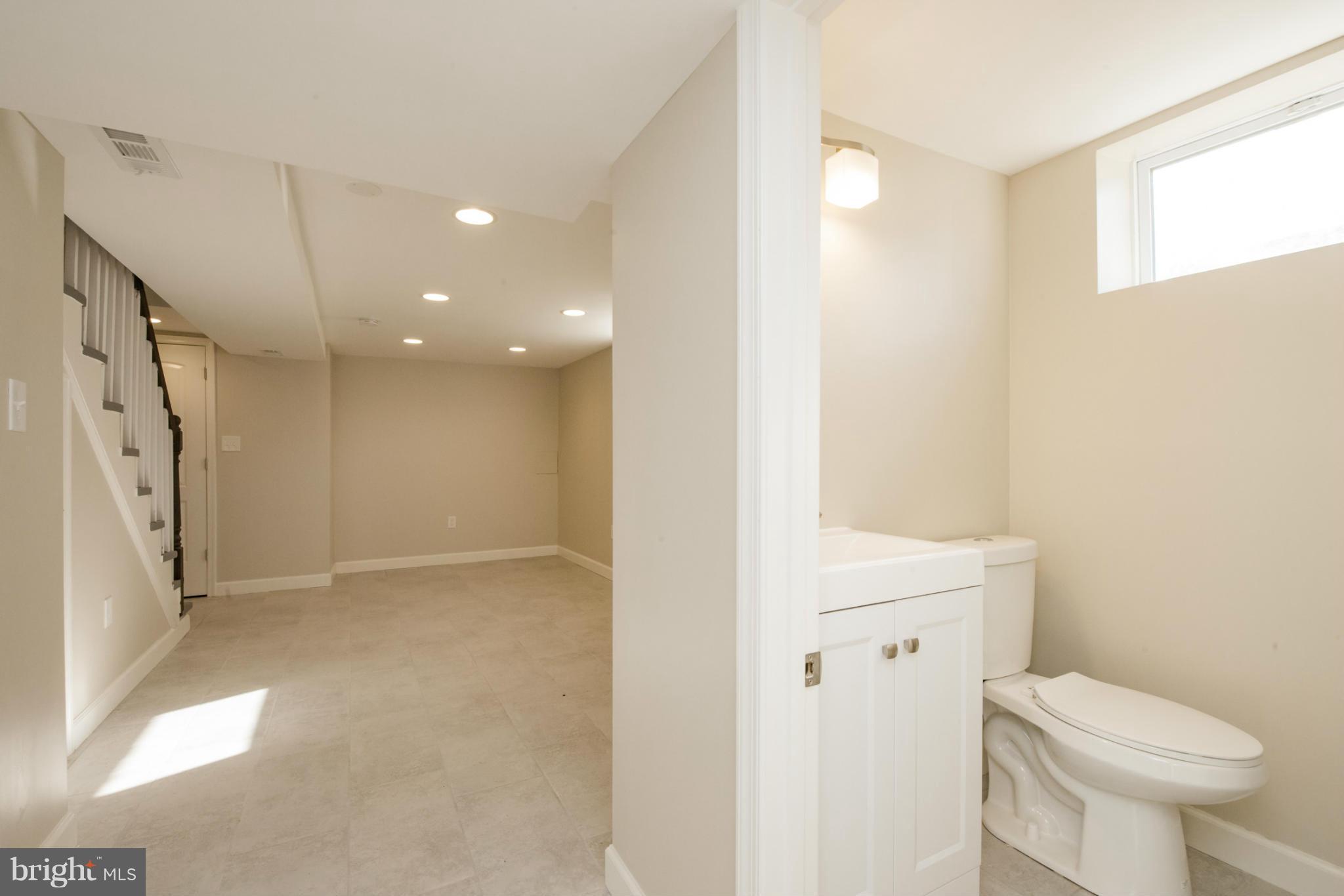 6922 Reisterstown Road Baltimore, MD 21215 - Photo 27 of 30 a bathroom with a toilet sink and a mirror
