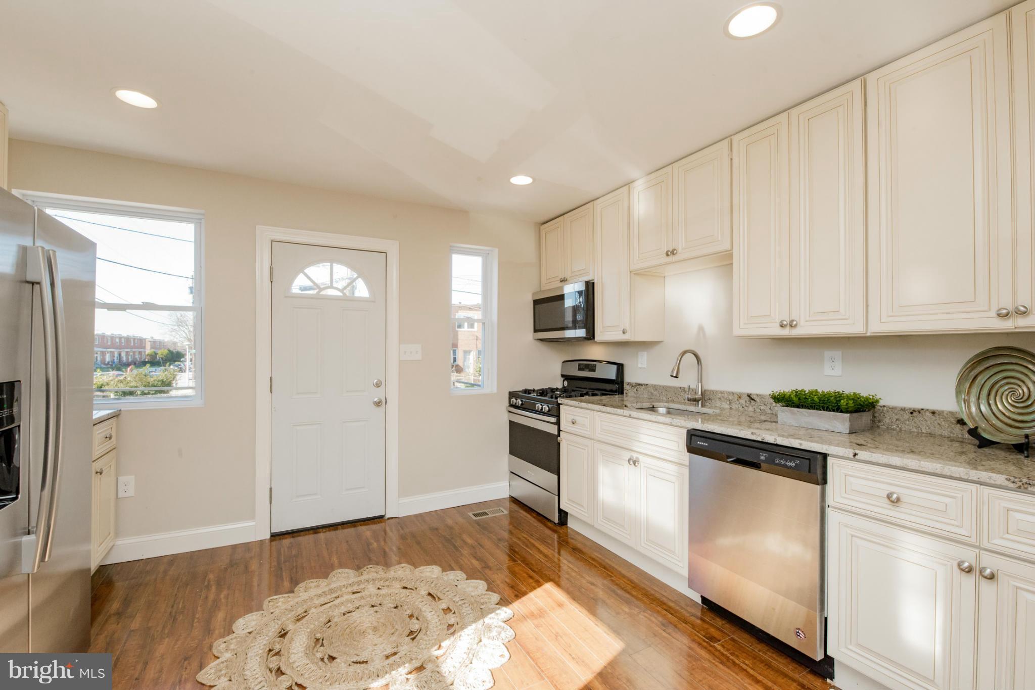 6922 Reisterstown Road Baltimore, MD 21215 - Photo 7 of 30 a kitchen with stainless steel appliances granite countertop a stove a sink and a refrigerator
