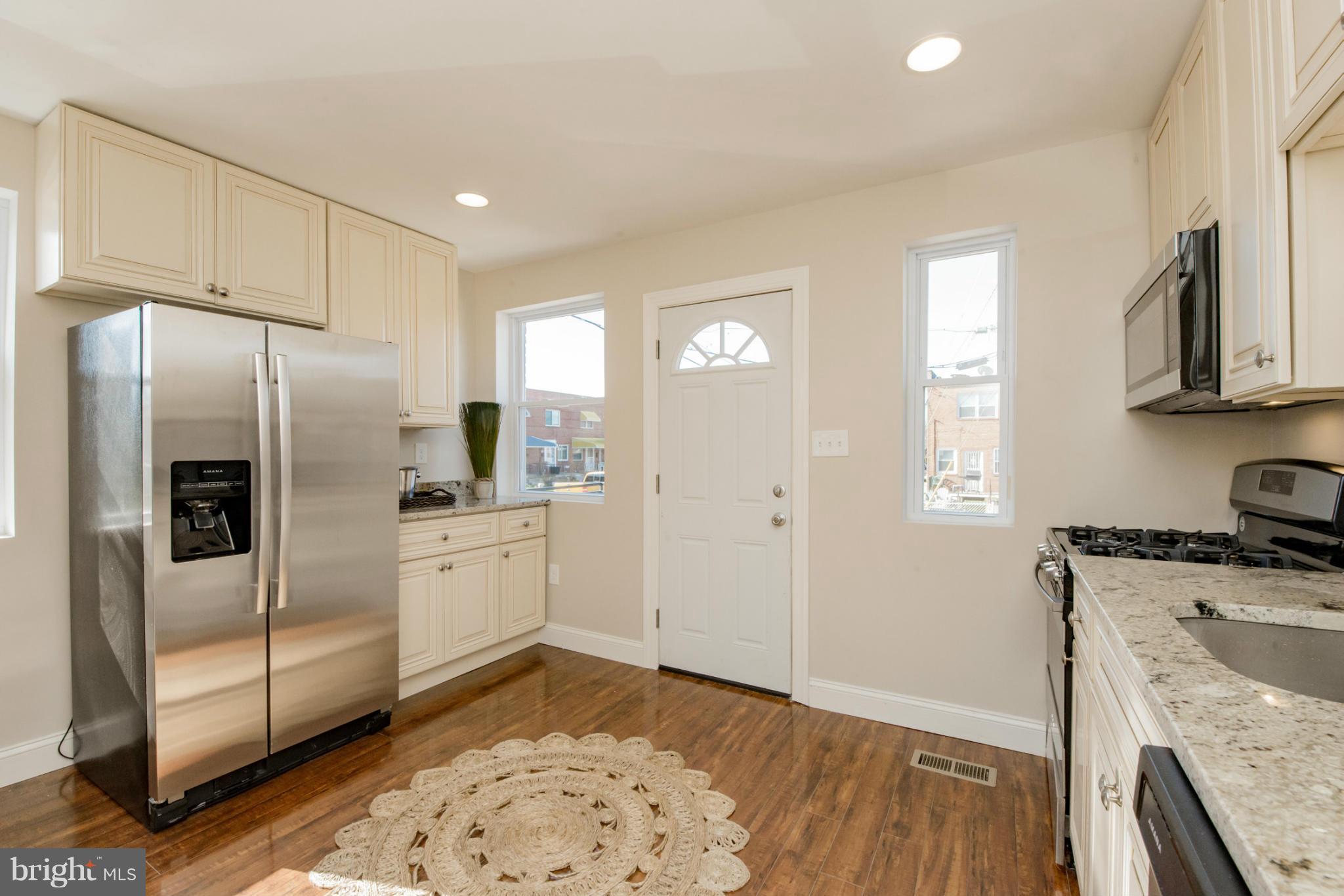 6922 Reisterstown Road Baltimore, MD 21215 - Photo 8 of 30 a kitchen with a refrigerator sink and cabinets