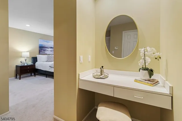 a bedroom with a bed and a lamp on dresser