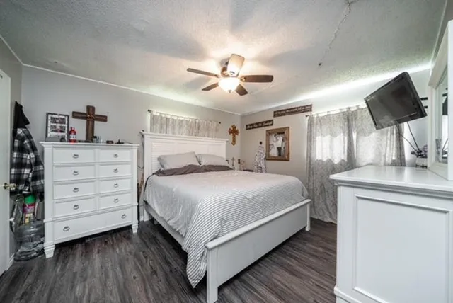 a bedroom with a bed and a flat tv screen on dresser