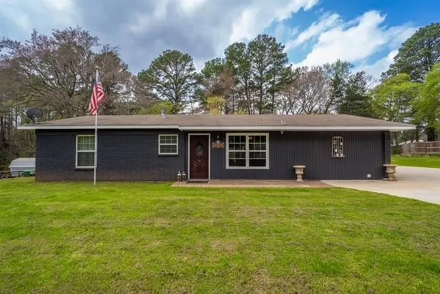 a view of a house with a yard and a tree