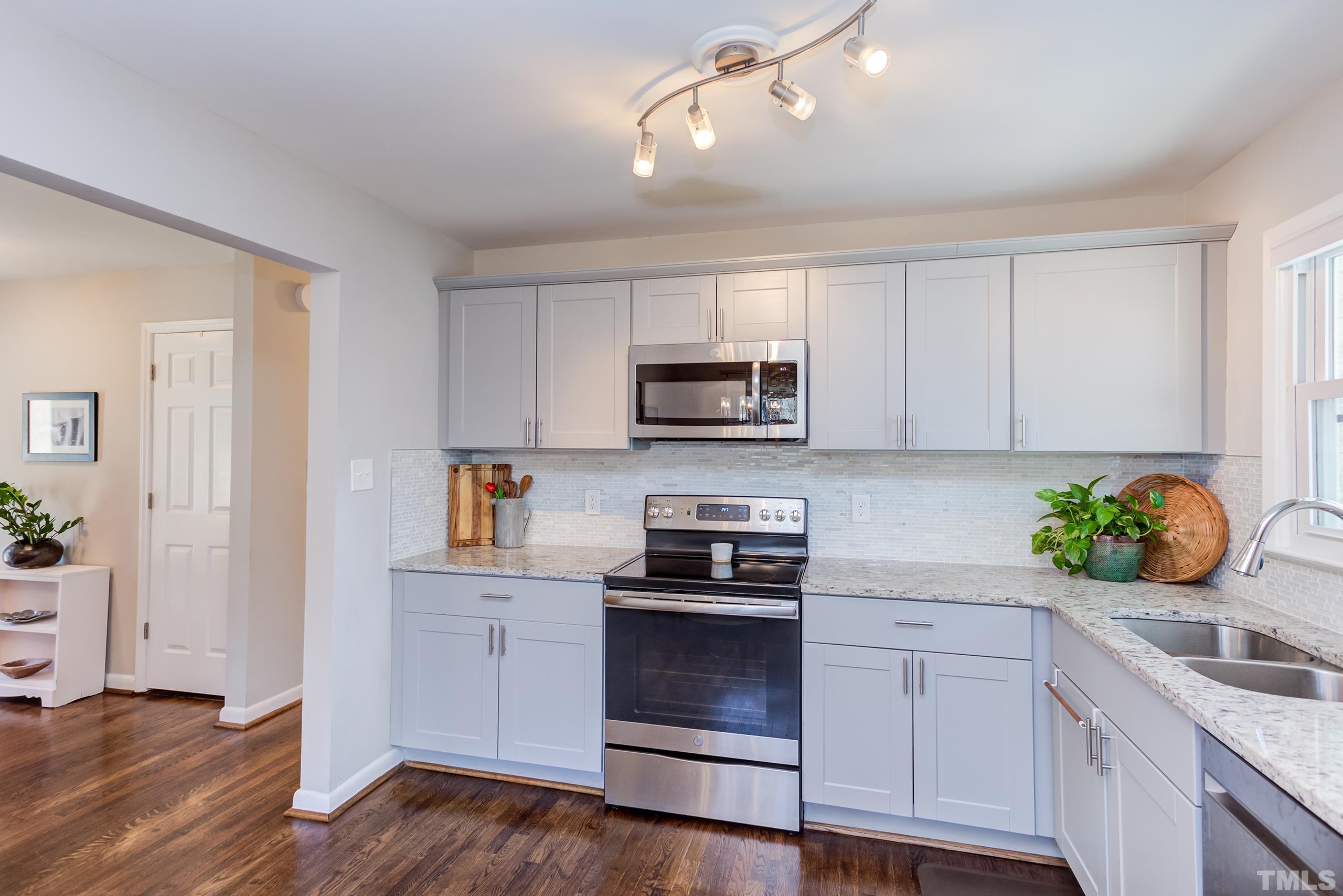 3314 Friar Tuck Road Raleigh, NC 27610 - Photo 9 of 42 a kitchen with granite countertop white cabinets and appliances