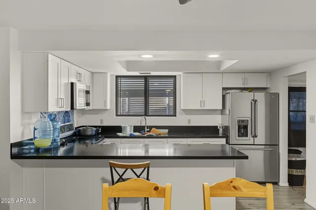 a kitchen with stainless steel appliances granite countertop a sink and a refrigerator