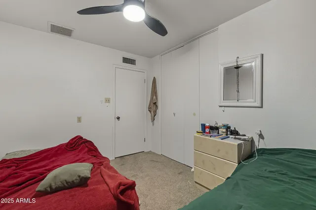 a bedroom with a bed and a chandelier fan