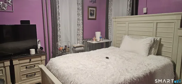 a bedroom with a bed and a flat screen tv