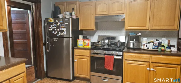 a kitchen with stainless steel appliances granite countertop a refrigerator and a stove