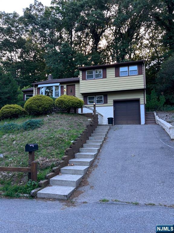 93 Knolls Road Bloomingdale, NJ 07403 - Photo 1 of 1 a front view of a house with a garden and trees