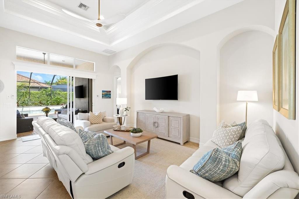 7831 Valencia Court Naples, FL 34113 - Photo 14 of 39 a living room with furniture and a flat screen tv