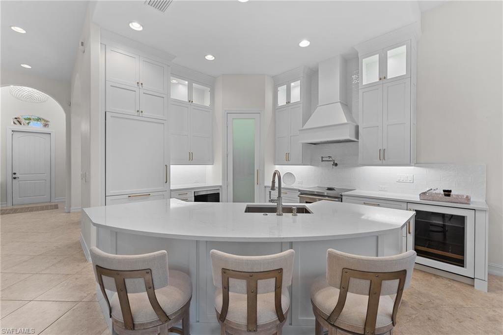 7831 Valencia Court Naples, FL 34113 - Photo 19 of 39 a kitchen with stainless steel appliances a sink table and chairs
