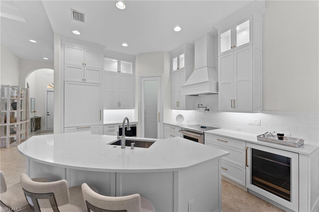 7831 Valencia Court Naples, FL 34113 - Photo 22 of 39 a kitchen with a white table chairs and a refrigerator