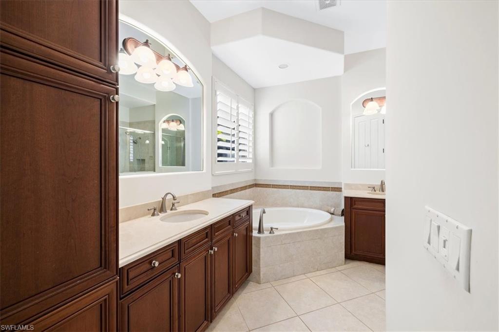 7831 Valencia Court Naples, FL 34113 - Photo 30 of 39 a bathroom with a tub sink and mirror