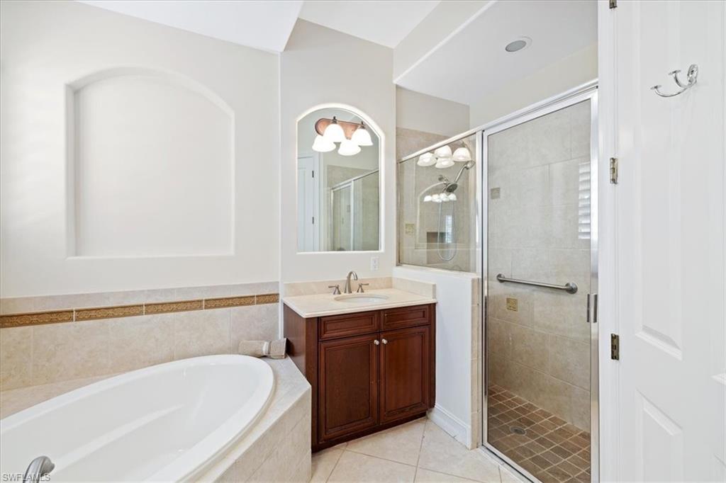 7831 Valencia Court Naples, FL 34113 - Photo 33 of 39 a spacious bathroom with a tub sink and mirror