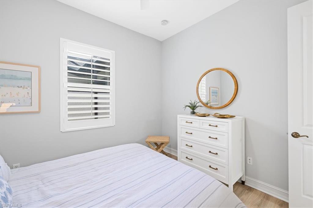 7831 Valencia Court Naples, FL 34113 - Photo 38 of 39 a bedroom with a bed and a dresser