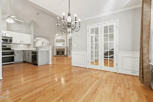 a large empty room with wooden floor and a fireplace