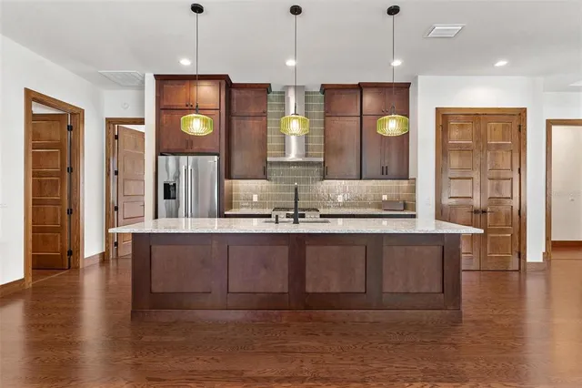 an open kitchen with granite countertop a sink and a wooden floor