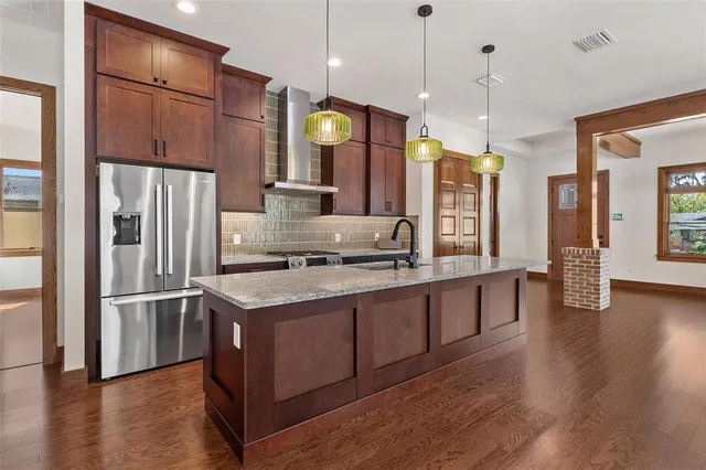 a kitchen with stainless steel appliances granite countertop a refrigerator a sink and a stove
