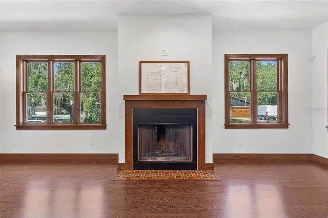 a living room with a fireplace and windows