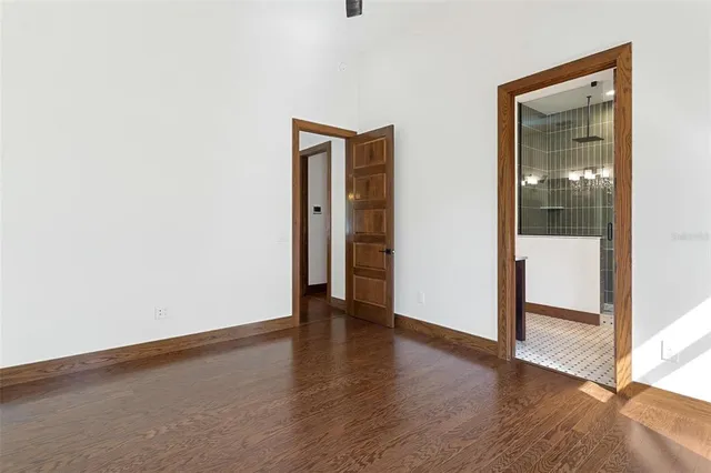 a view of an empty room with wooden floor and closet