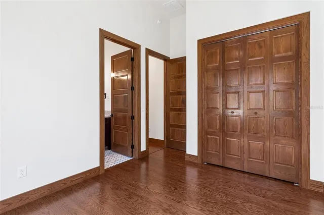 an empty room with wooden floor and closet