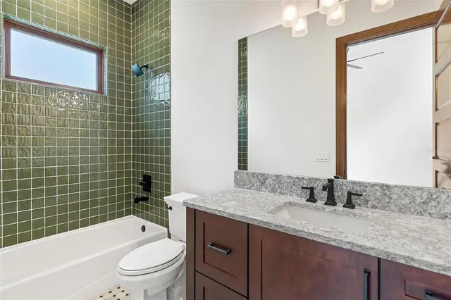a bathroom with a granite countertop toilet a sink and a bathtub