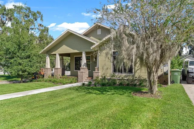 a view of a house with a big yard plants and large trees