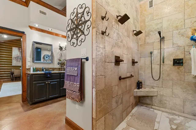 a bathroom with a granite countertop shower a mirror and a sink