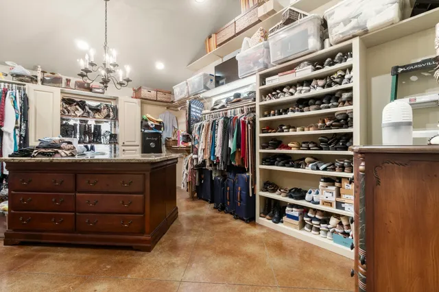 a view of walk in closet with clothes and shoes
