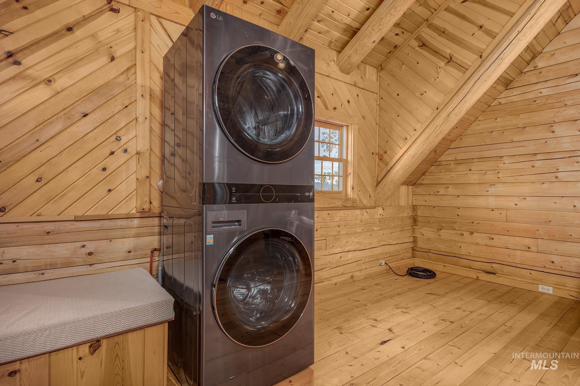 2150 Seid Creek Road Cambridge, ID 83610 - Photo 46 of 50 Stacked laundry appliances within a room featuring wood-finish walls and ceiling