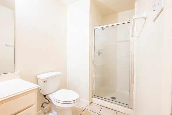 a white toilet sitting next to a shower