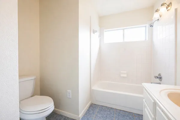 a white toilet sitting next to a bath tub