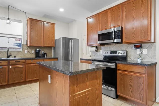 a kitchen with stainless steel appliances granite countertop a refrigerator stove microwave sink and cabinets
