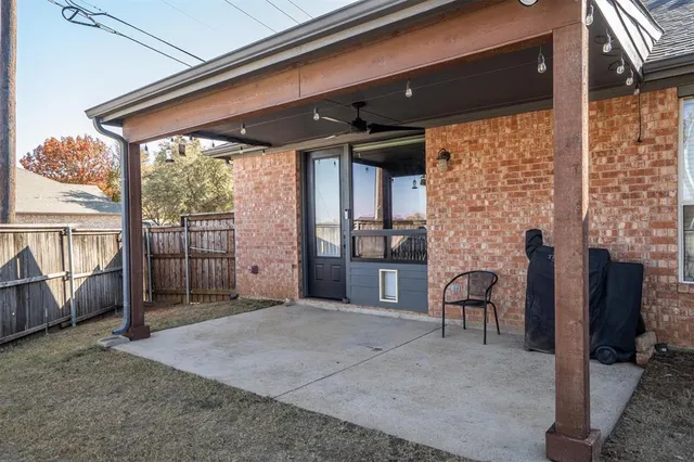 a view of a porch with chairs and floor to ceiling window