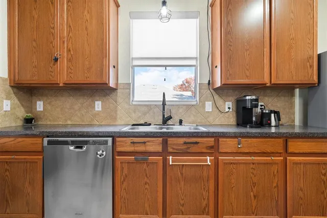 a kitchen with stainless steel appliances granite countertop white cabinets sink and a granite counter top