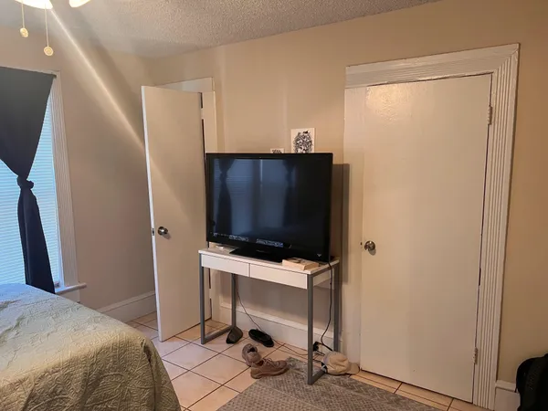 a bedroom with a bed and a flat screen tv