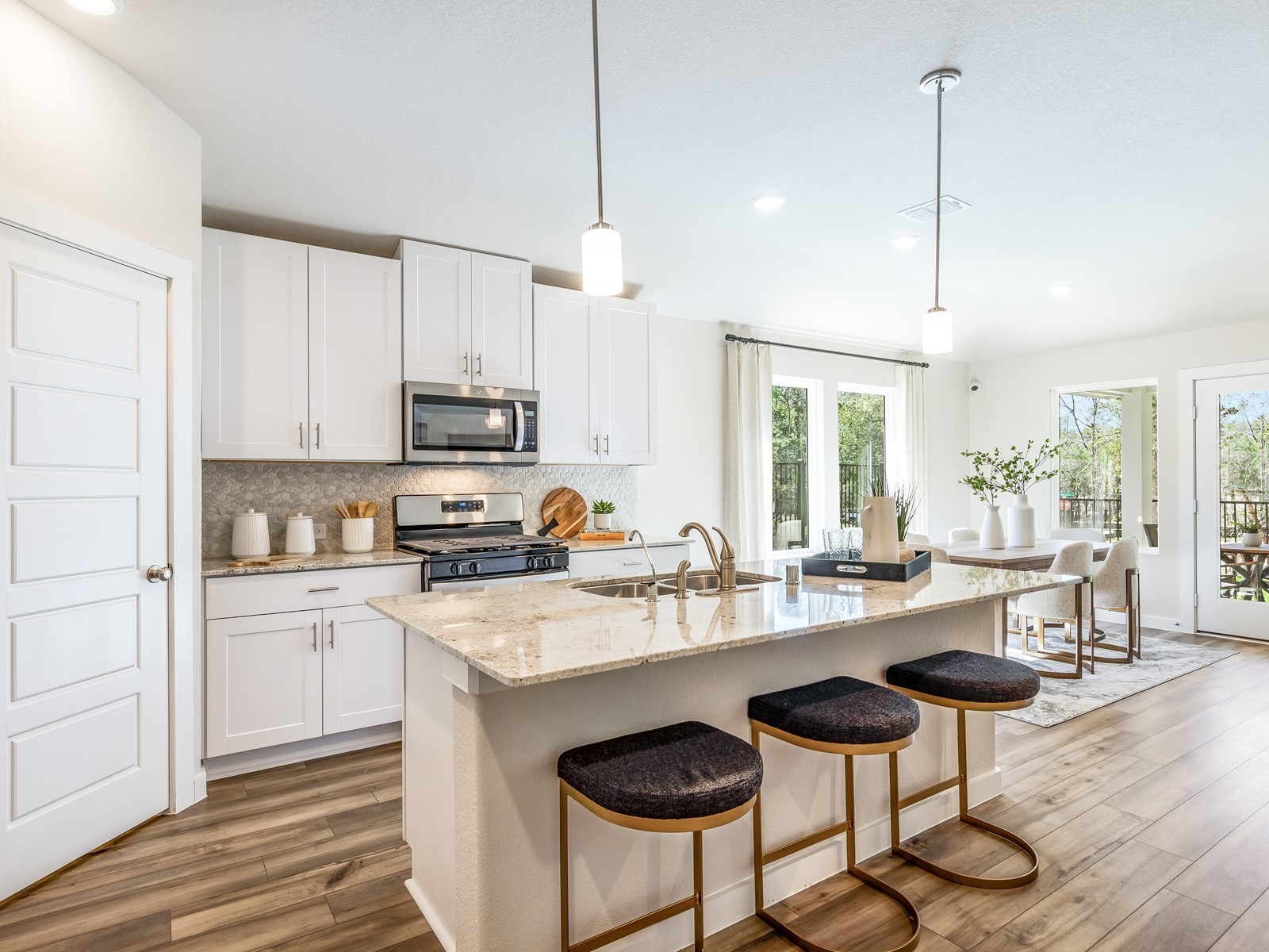 a kitchen with granite countertop a stove a sink and a refrigerator with wooden floor