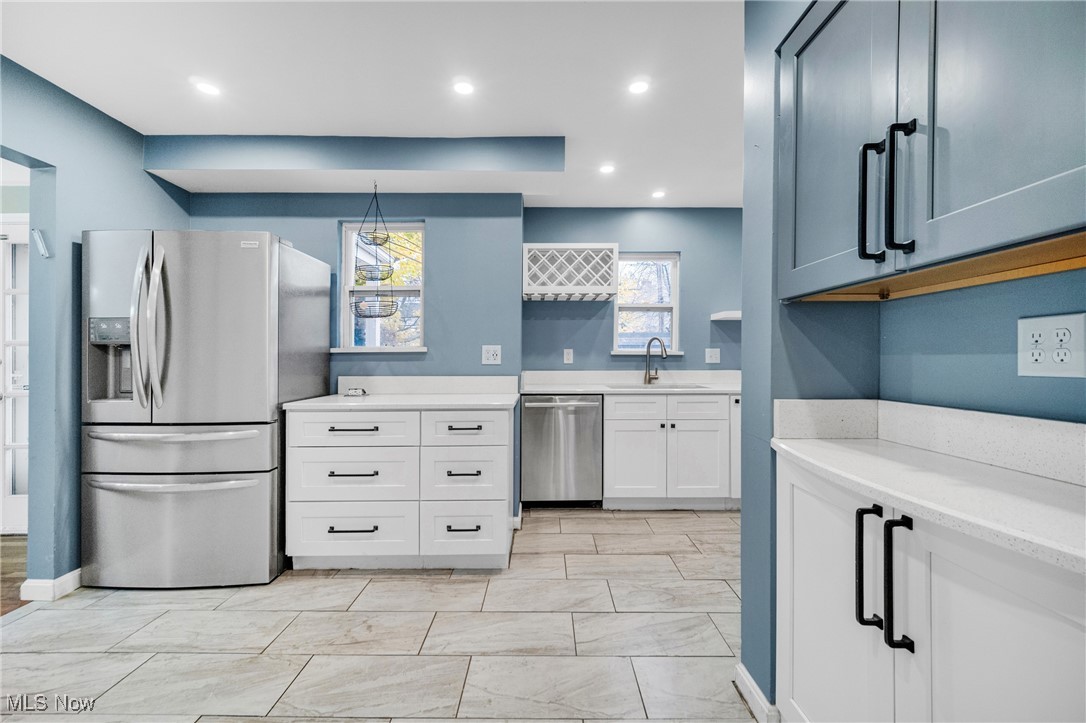 4430 Silsby Road Cleveland, OH 44118 - Photo 18 of 43 Kitchen featuring appliances with stainless steel finishes, white cabinetry, pendant lighting, and sink