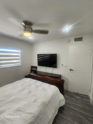 a bedroom with a bed and a flat screen tv