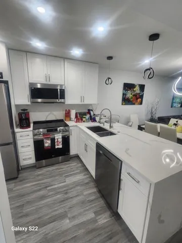 a kitchen with a sink a microwave a stove and cabinets